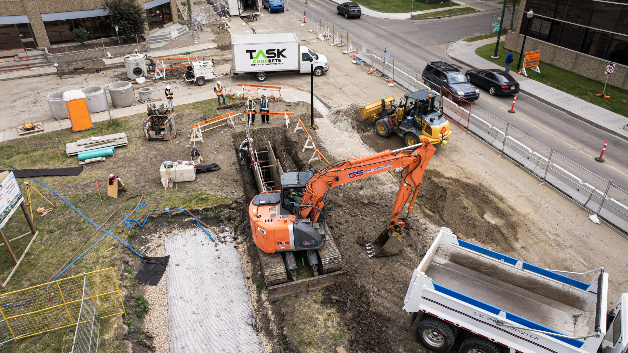 Edmonton Valley Line West LRT sanitary and storm realignment with GS Construction crews installing underground infrastructure using shoring and excavation equipment