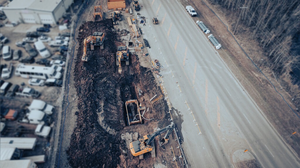 Aerial view of excavation along roadway during transmission main repair project in Edmonton