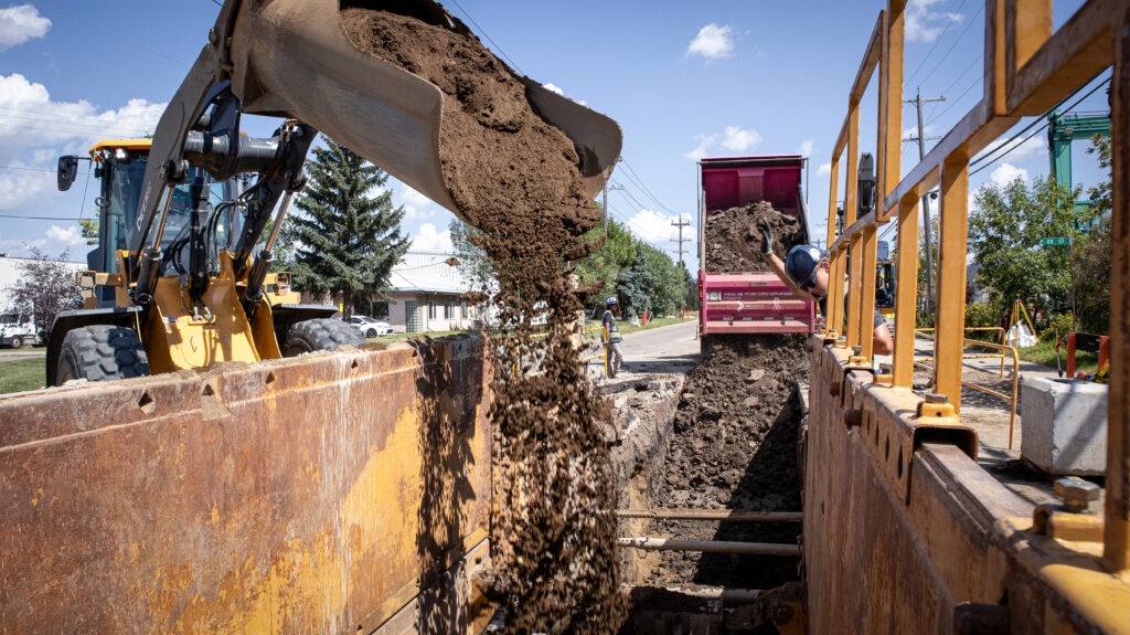 Placing material into trench during transmission main construction