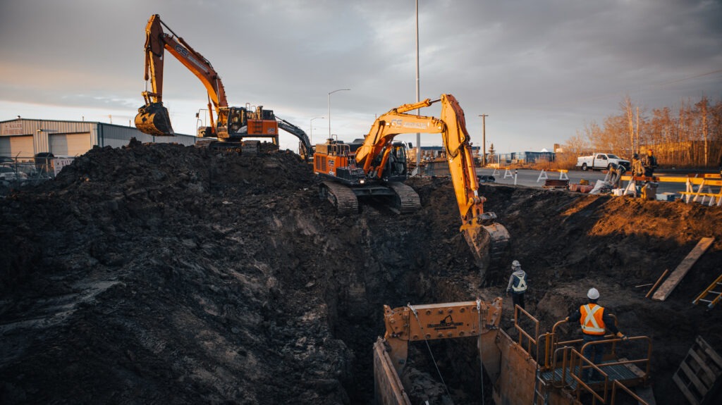 Excavators working in deep trench during transmission main repair project
