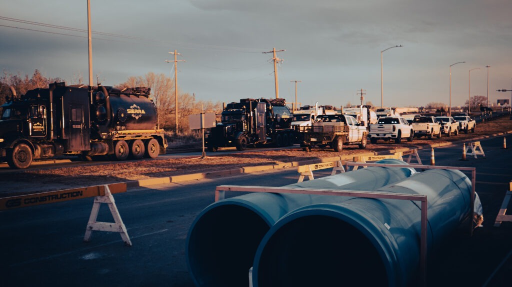 Large diameter watermain pipes staged on roadway for installation during infrastructure project