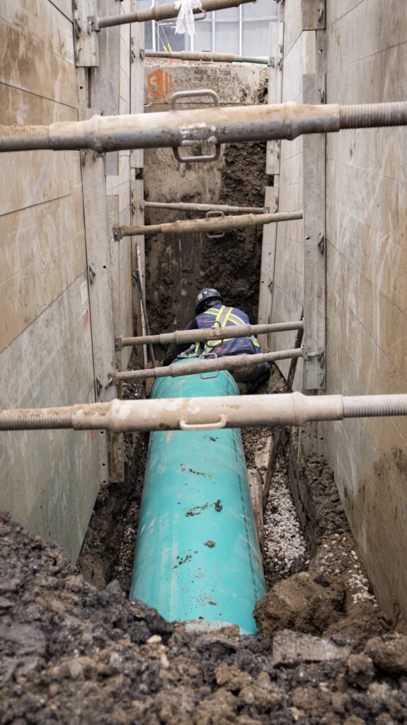 GS Construction worker inside an excavation completing pipe installation work on the West Valley LRT project