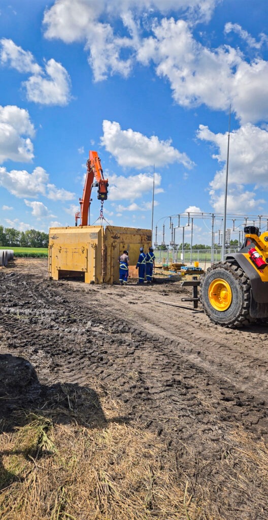 Excavator preparing to install an underground metal trench box shoring for stormwater infrastructure work