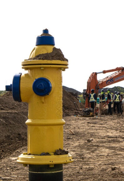 GS Construction crew installing municipal water infrastructure and hydrant at new neighbourhood underground infrastructure construction site