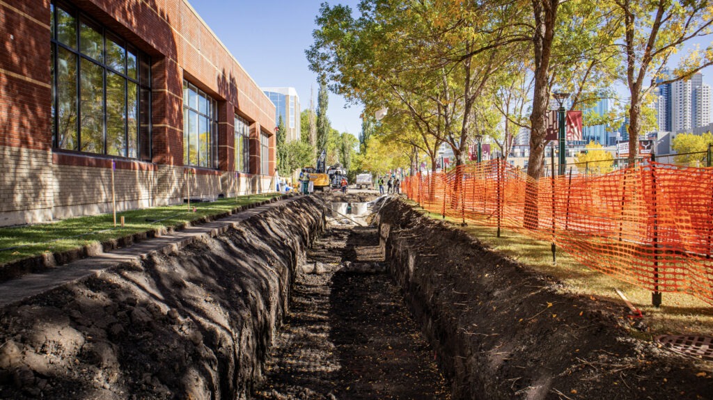 Wide-angle view of a construction trench with catch basins installed at the end