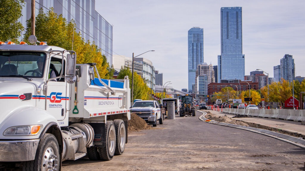 Completed section of the MacEwan University LID Project with a loader and dumper truck staged nearby in downtown Edmonton