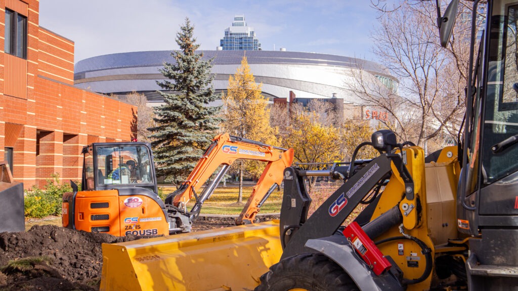 GS Construction equipment operating on site, including a small excavator and dozer
