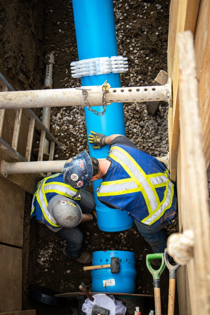 Large-diameter transmission watermain installation with exposed pipe.