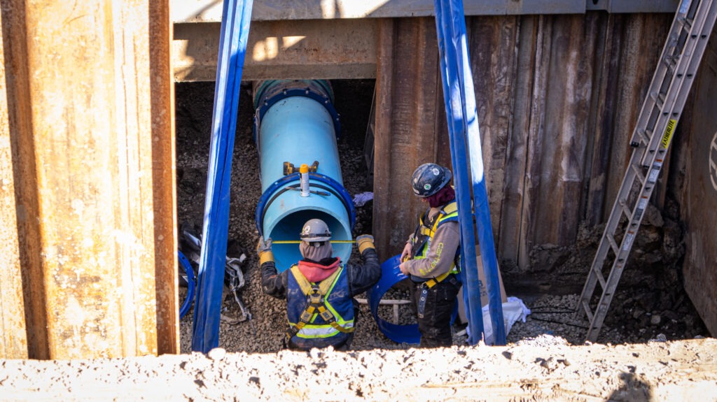 Slide rail shoring system supporting deep watermain excavation.